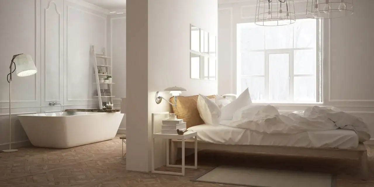 Chambre moderne avec baignoire îlot, lit douillet et grande fenêtre. Un espace de vie où le confort d'une chambre rencontre la détente d'une wet room.