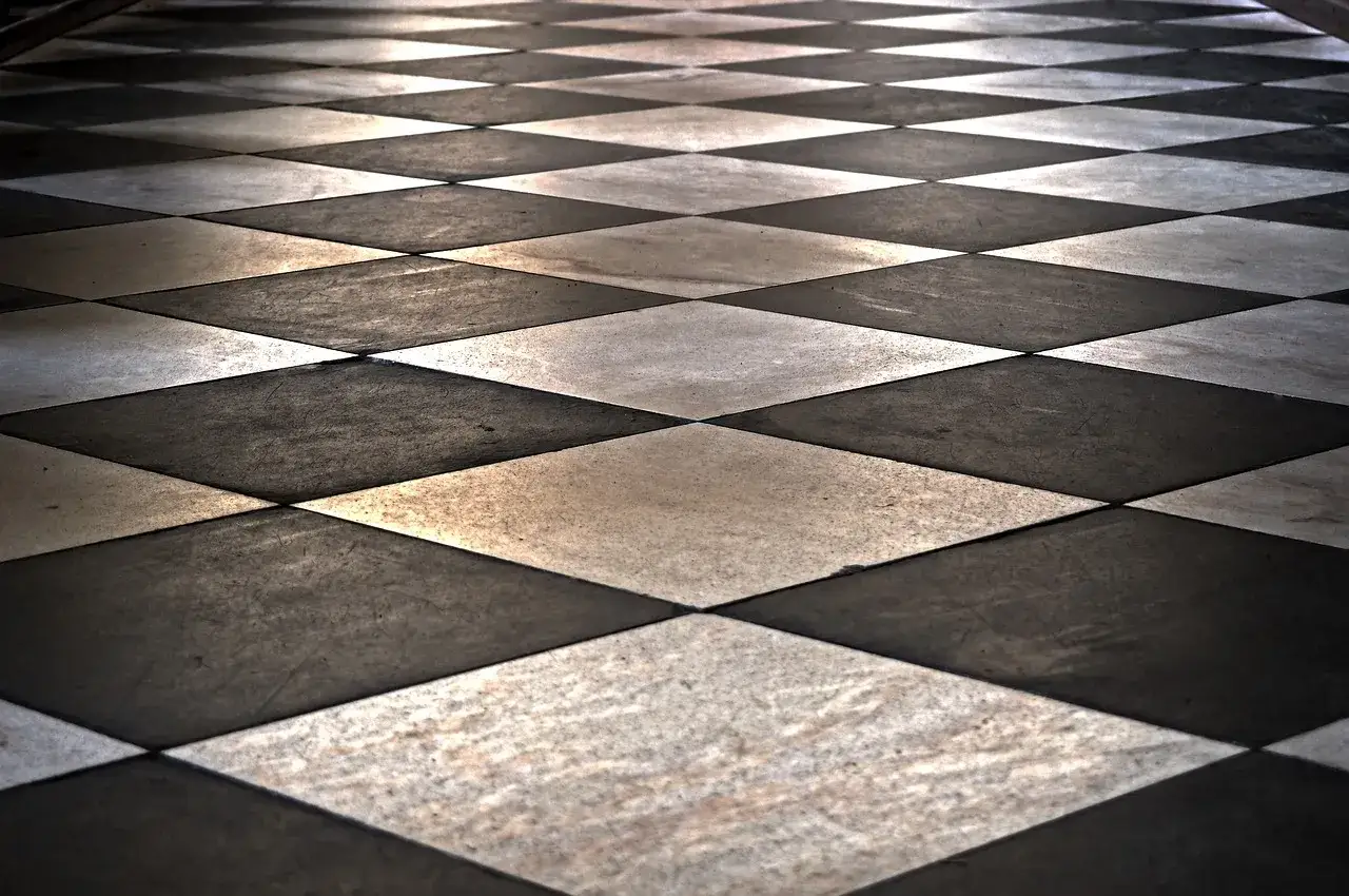 Un sol en damier noir et blanc, avec un calepinage carrelage 60x60 qui crée une perspective hypnotique.