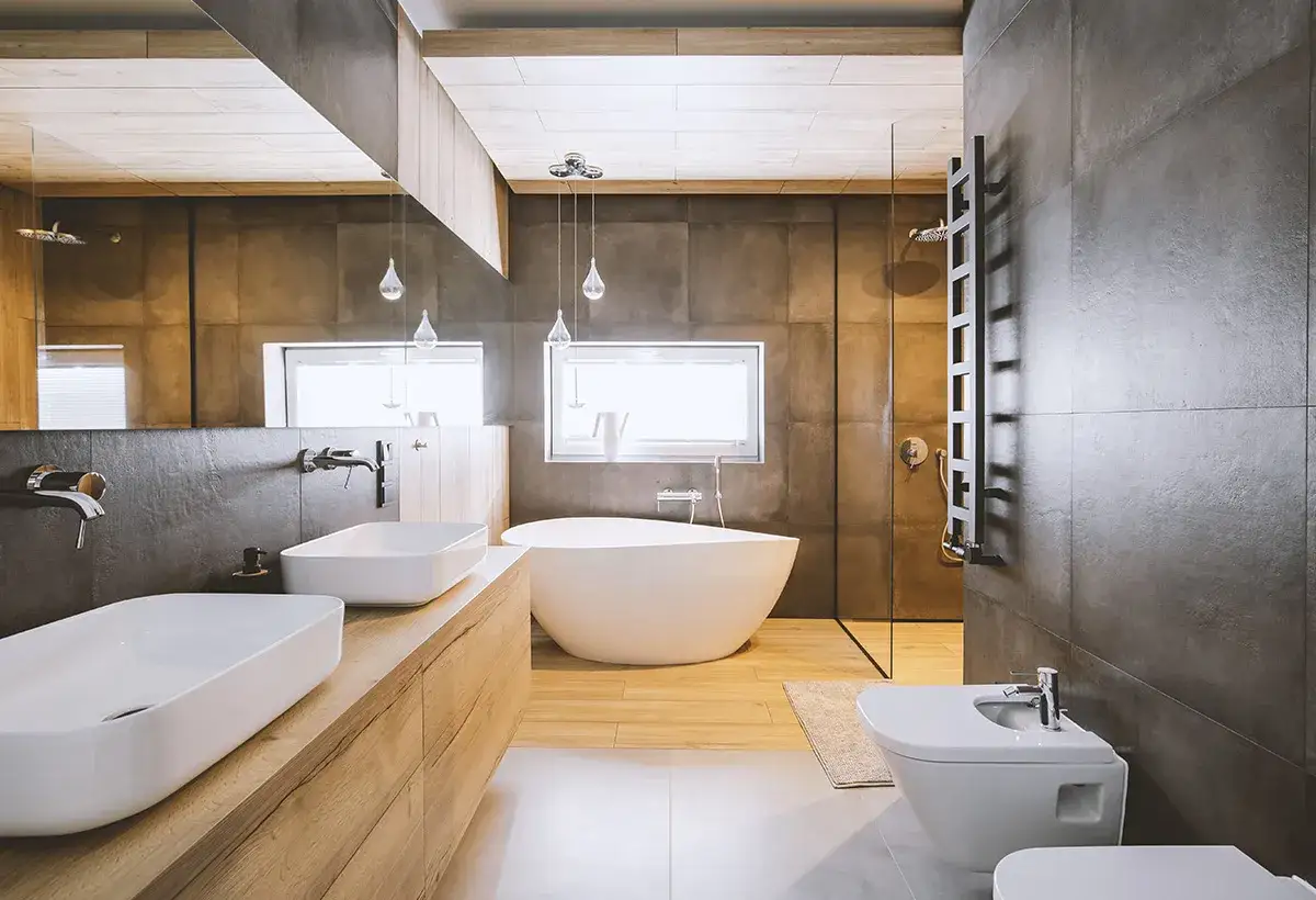 Salle de bain en longueur avec deux lavabos, une baignoire îlot, une douche et un bidet. Ambiance moderne et épurée.