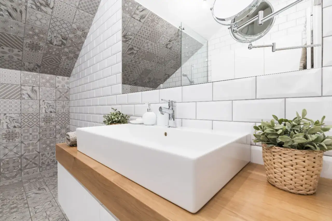 Une petite salle de bain moderne avec un lavabo rectangulaire, des murs en carrelage blanc métro et des carreaux décoratifs gris. Une belle idée carrelage petite salle de bain.