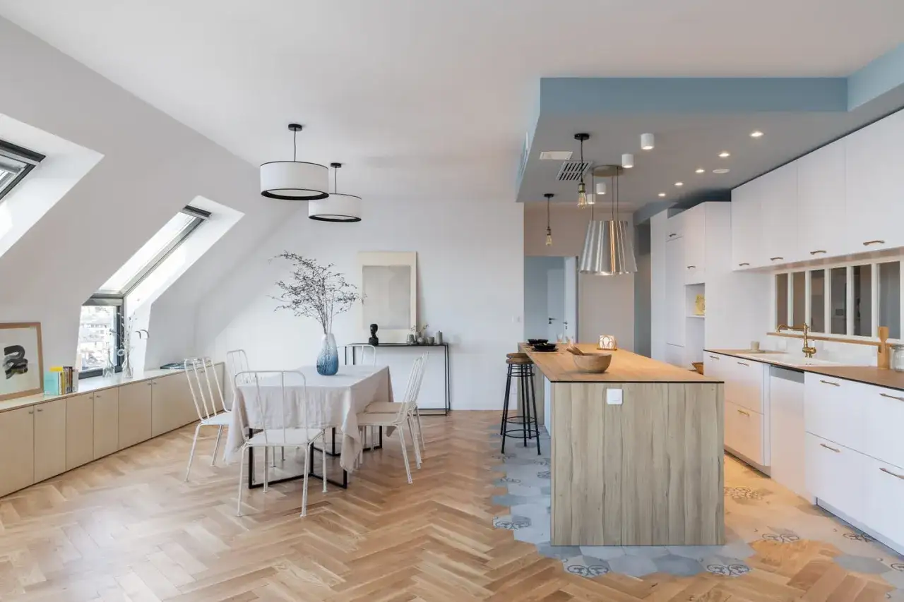 Un élégant mixer carrelage et parquet dans une cuisine moderne. Le parquet en chevrons rencontre un carrelage géométrique, créant un espace unique.
