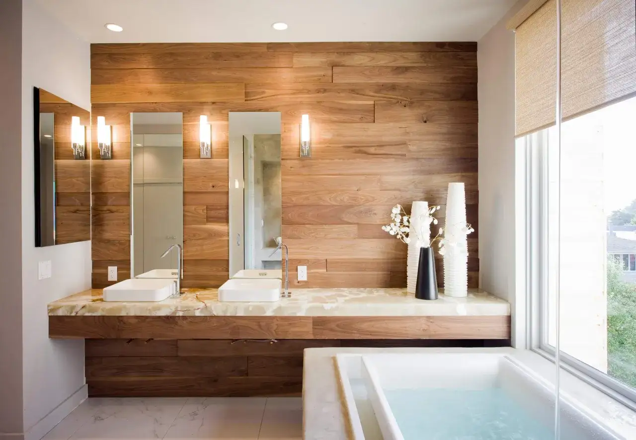 Double vasque moderne avec mur en bois, éclairage d'ambiance et baignoire invitant à la détente. Une ambiance salle de bain chic et naturelle.