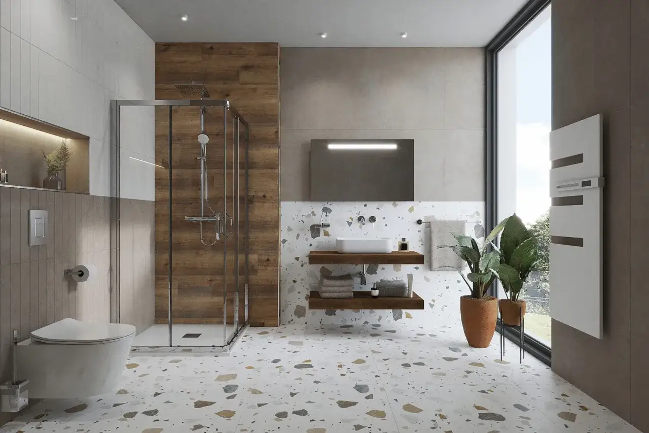 Une salle de bain minimaliste avec douche vitrée, lavabo suspendu, et sol en terrazzo coloré. L'ambiance est épurée et moderne.