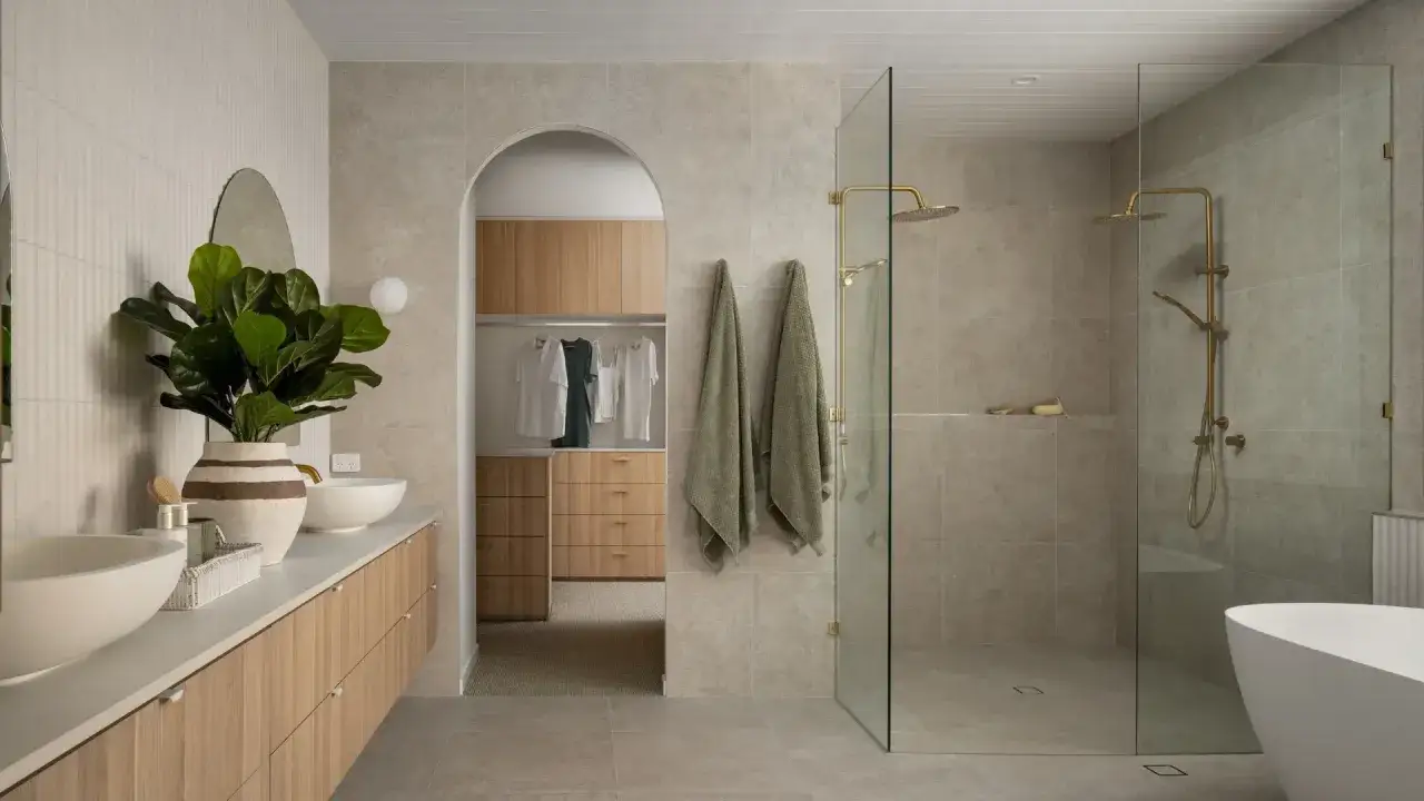 &Eacute;l&eacute;gante salle de bain m&eacute;diterran&eacute;enne avec double vasque, douche vitr&eacute;e et baignoire. Un dressing ouvert avec des portes en bois clair compl&egrave;te l'espace.