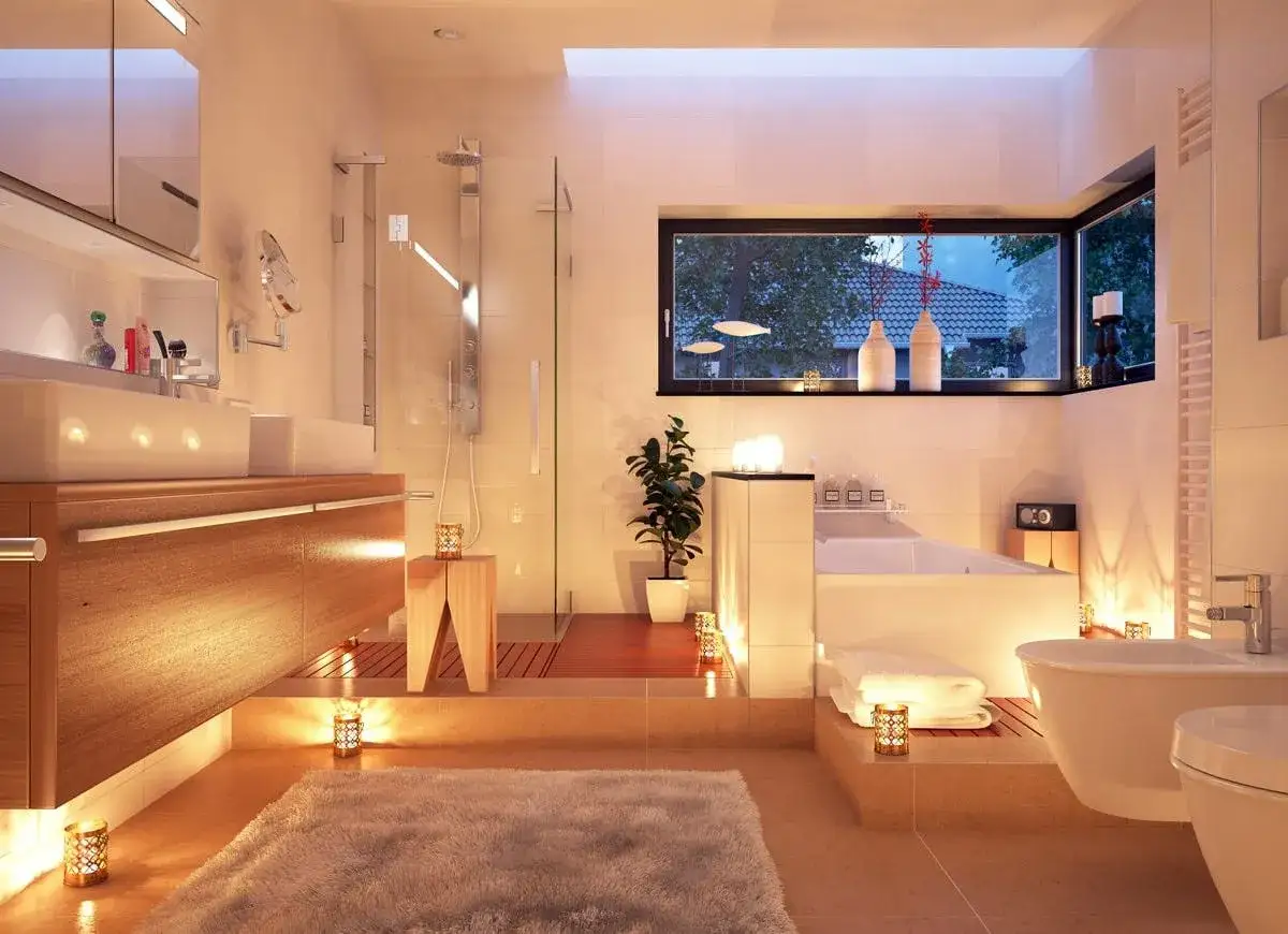 Salle de bain moderne et apaisante, baign&eacute;e de lumi&egrave;re douce. Quel luminaire pour salle de bain choisir pour une ambiance aussi cosy ? Douche, baignoire, double vasque, tout est l&agrave;.