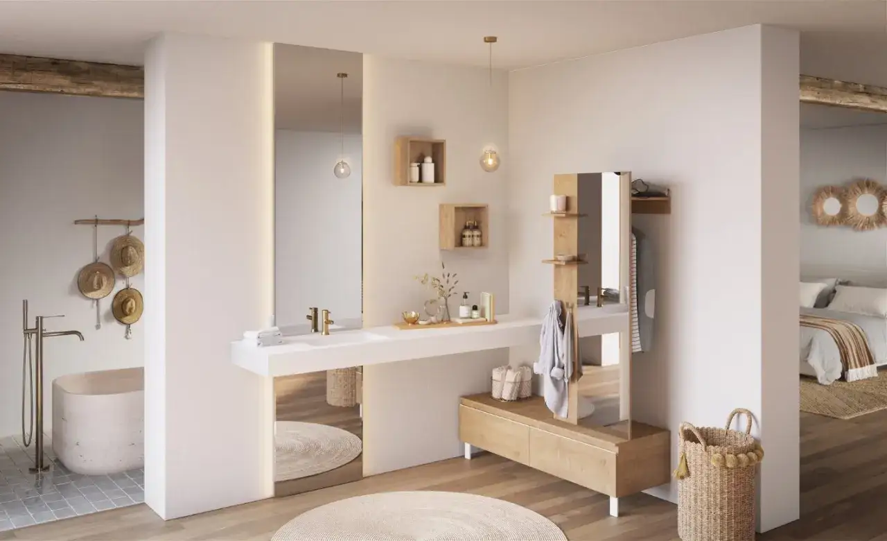 Une élégante salle de bain dans chambre, avec baignoire, lavabo, miroirs et rangements en bois.