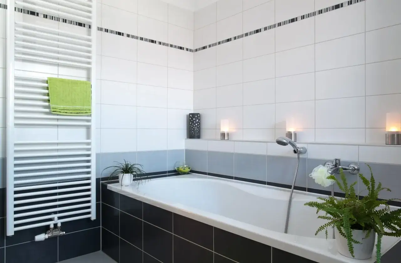 Salle de bain moderne avec baignoire, carrelage blanc et noir. Estimation du prix pose carrelage m2 pour un tel projet.