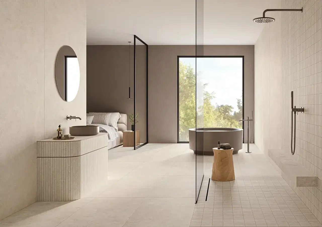 Salle de bain moderne avec baignoire, douche et lavabo. Le sol et les murs sont recouverts de grès cérame pleine masse, créant une ambiance épurée et naturelle.