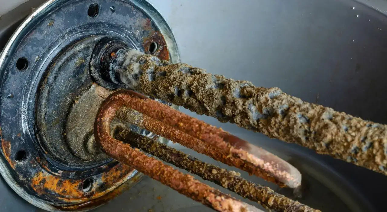 &Eacute;l&eacute;ments chauffants d'un chauffe-eau tr&egrave;s entartr&eacute;s, montrant l'accumulation de calcaire due au manque de d&eacute;tartrage.