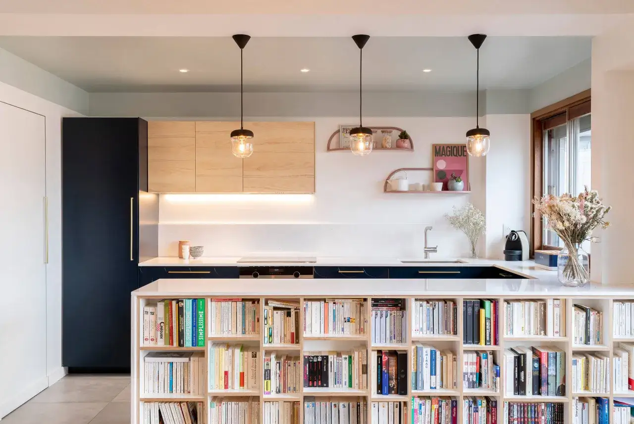Cuisine moderne avec étagères remplies de livres, idéale pour rénover une cuisine avec style et fonctionnalité.