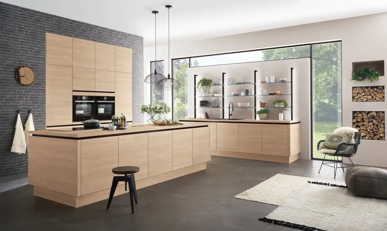 Cuisine moderne avec des armoires en bois clair. Le mur de briques grises contraste avec la couleur mur cuisine.