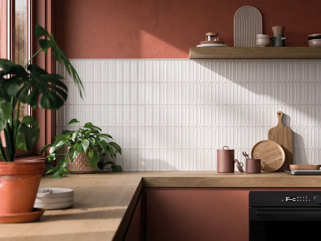 Cuisine moderne avec mur carrelé blanc aux formes arrondies, facile à nettoyer. Des plantes vertes apportent de la fraîcheur.
