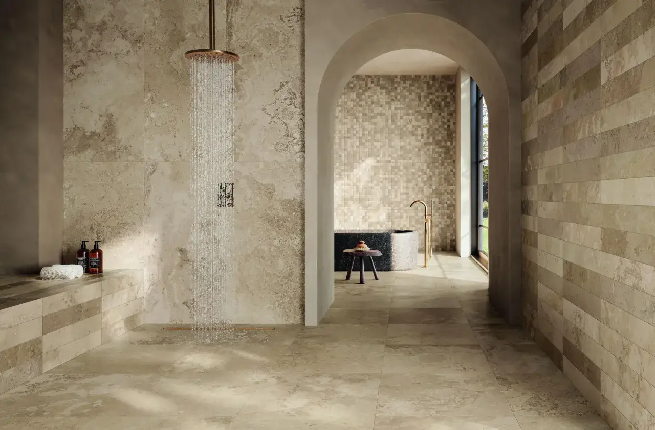 Salle de bain luxueuse avec douche à effet pluie. Le couleur sol salle de bain est un mélange de tons sable et terreux, rappelant la pierre naturelle.