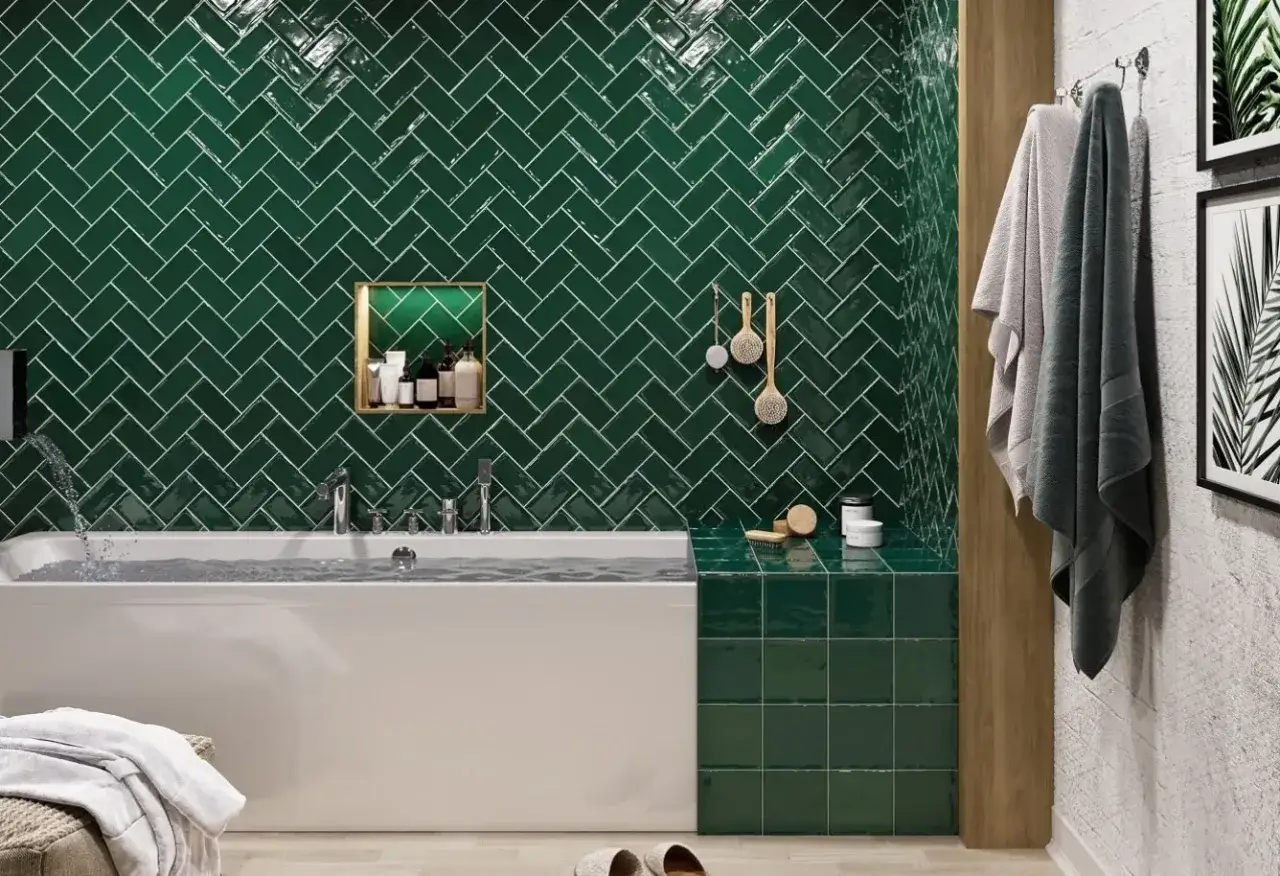 Une salle de bain travertin et vert luxueuse avec des carreaux émeraude en chevrons, une baignoire moderne et des accessoires de spa.