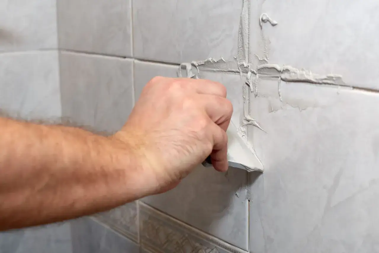 Application d'enduit sur les joints de carrelage pour un nettoyage en profondeur.