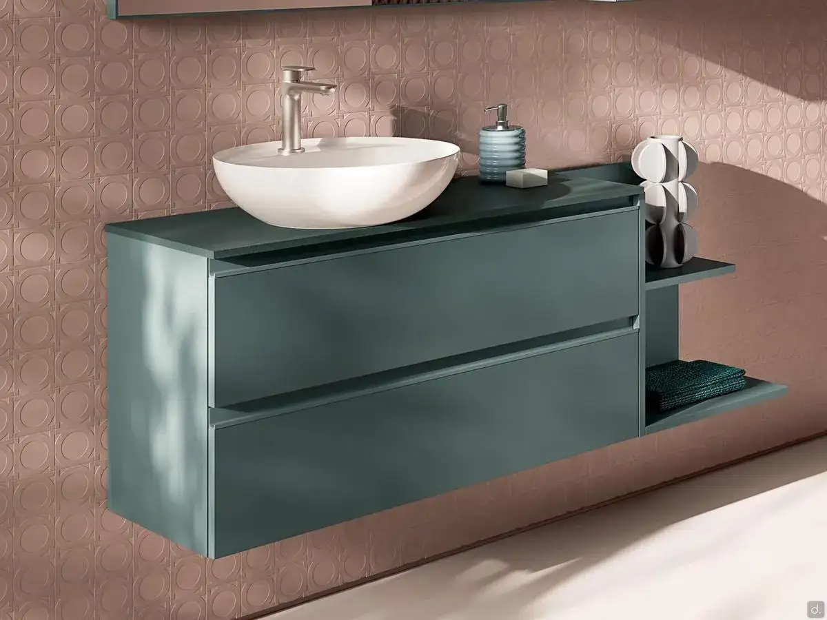 Meuble salle de bain suspendu vert émeraude, offrant une belle profondeur avec ses deux tiroirs et une étagère. Un lavabo blanc et un robinet argenté complètent l'ensemble.