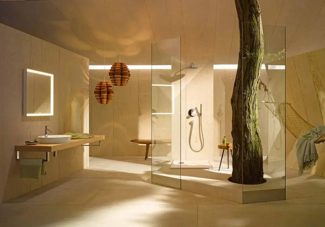Une salle de bain minimaliste avec un arbre au milieu, une douche en verre, un lavabo flottant et une balançoire.