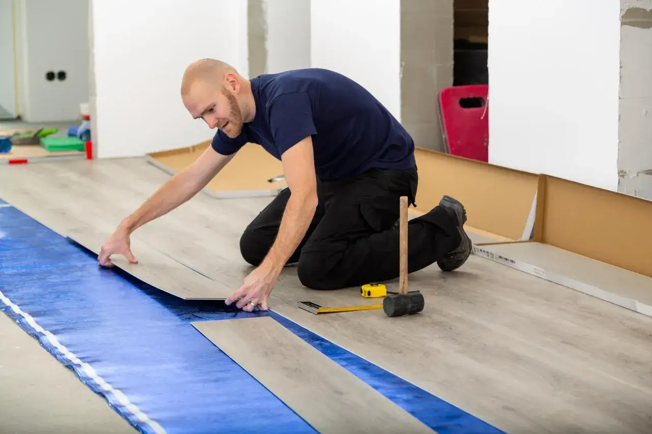 Pose d'un revêtement de sol stratifié sur une sous-couche bleue, assurant une isolation phonique sous carrelage.
