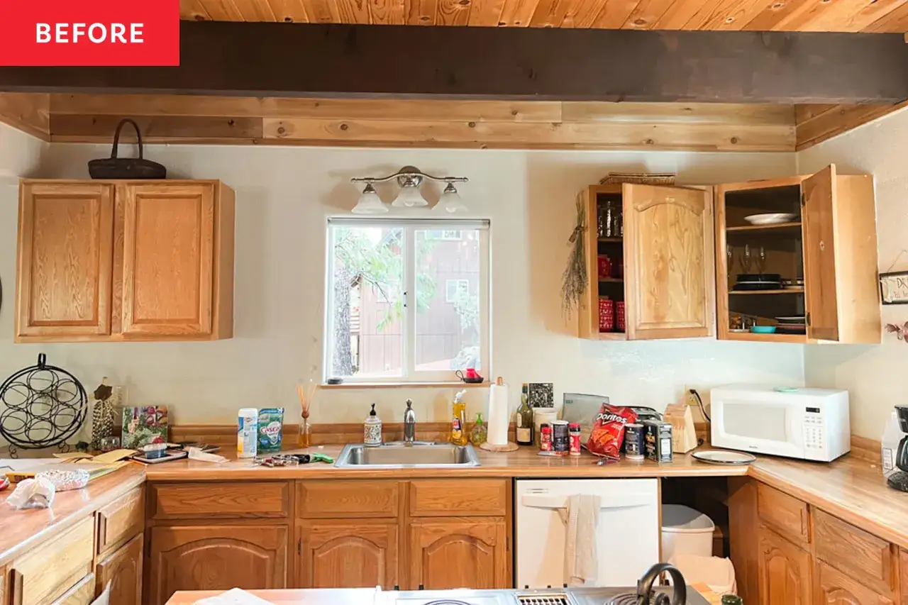 Avant : cuisine en bois avant home staging, avec des placards en chêne clair et un plan de travail encombré.