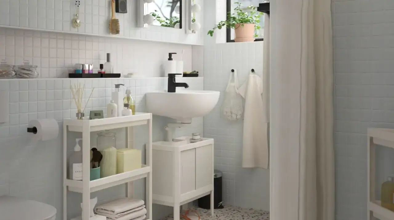 Une étagère roulante offre une astuce rangement petite salle de bain, organisant savons, serviettes et accessoires près du lavabo.
