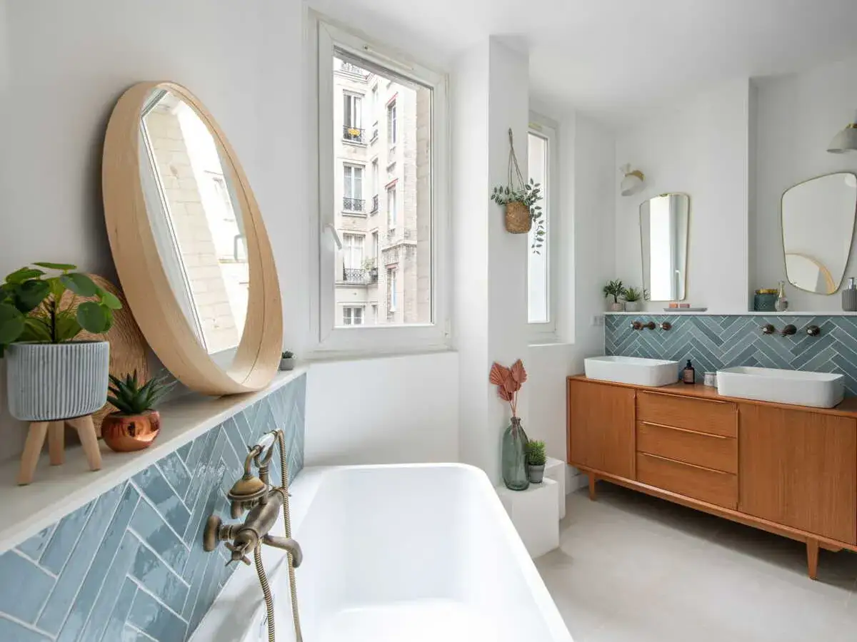 Salle de bain moderne avec baignoire, double vasque sur meuble vintage et crédence en carreaux wc zellige bleu canard.