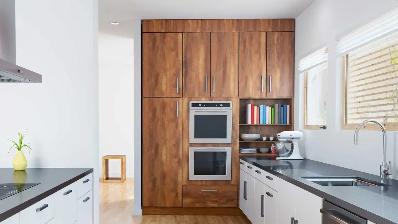 Cuisine moderne avec armoires en bois, deux fours encastrables, et un dimension micro onde encastrable intégré.
