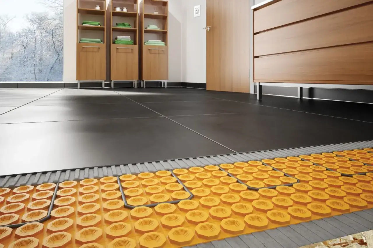 Coupe d'un carrelage moderne avec système de chauffage au sol intégré, promettant un confort douillet même par temps froid.