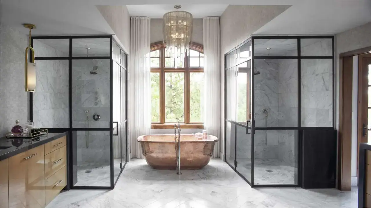 Salle de bain luxueuse avec deux cabines de douche vitr&eacute;es, une baignoire en cuivre et une grande fen&ecirc;tre. La dimension cabine de douche est g&eacute;n&eacute;reuse.