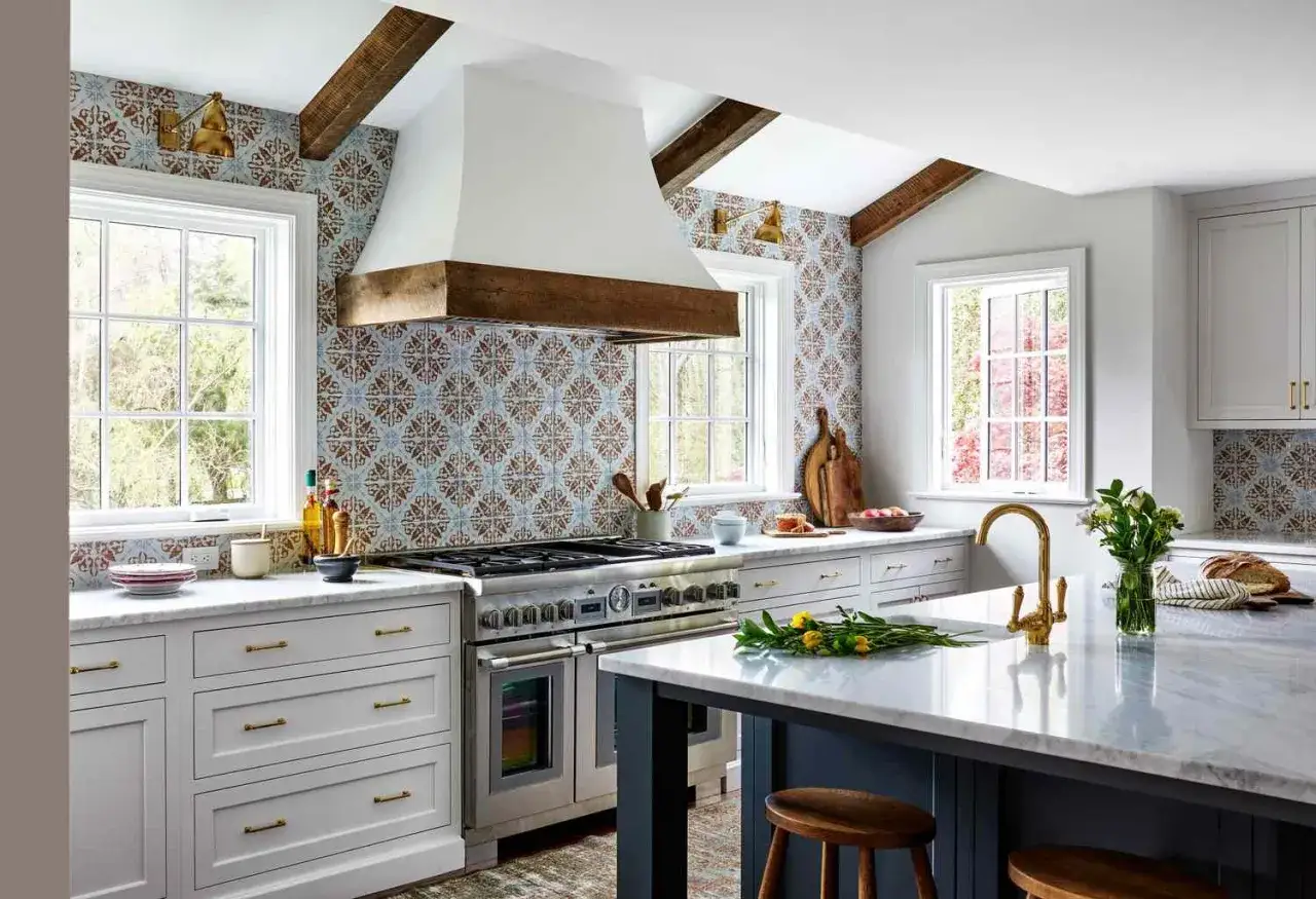 Cuisine moderne avec hotte aspirante blanche et bois, carrelage décoratif, et îlot central. Idéal pour savoir comment choisir une hotte aspirante.