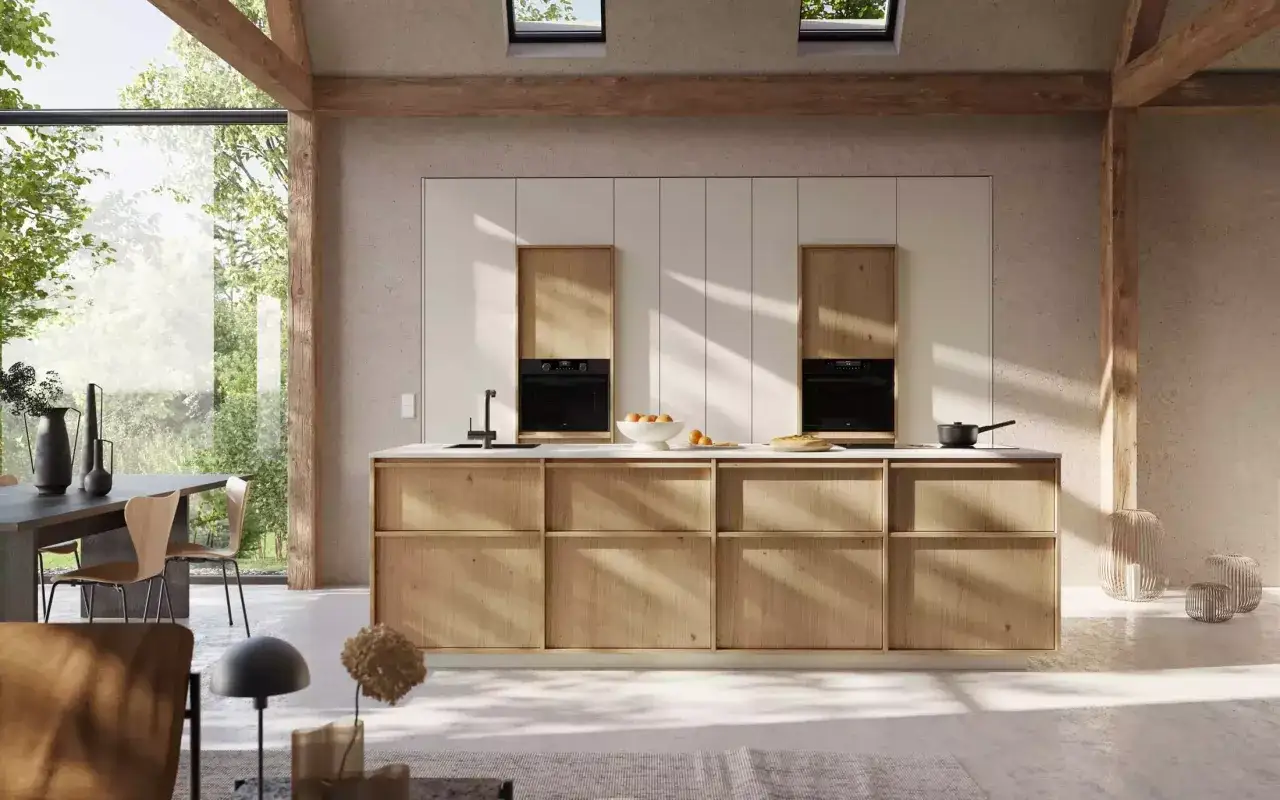 Une cuisine campagne chic avec des poutres apparentes, des meubles en bois clair et une grande baie vitrée donnant sur la verdure.