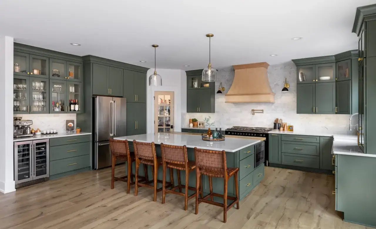 Cuisine vert d'eau et bois, avec &icirc;lot central, tabourets en cuir et hotte en bois. L'espace est lumineux et moderne.