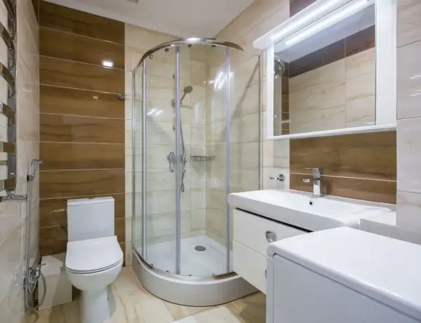 Salle de bain moderne avec douche à l'italienne, lavabo, WC et un banc intégré dans la douche pour plus de confort.
