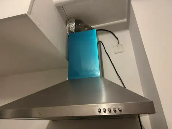 Hotte aspirante en inox avec conduit d'évacuation argenté. Il est temps de nettoyer filtre hotte pour une cuisine plus saine.