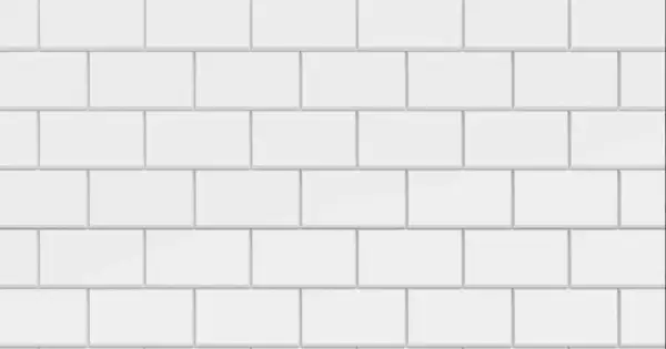 Vue rapprochée d'une pose carrelage métro blanche, avec des carreaux rectangulaires disposés en quinconce.