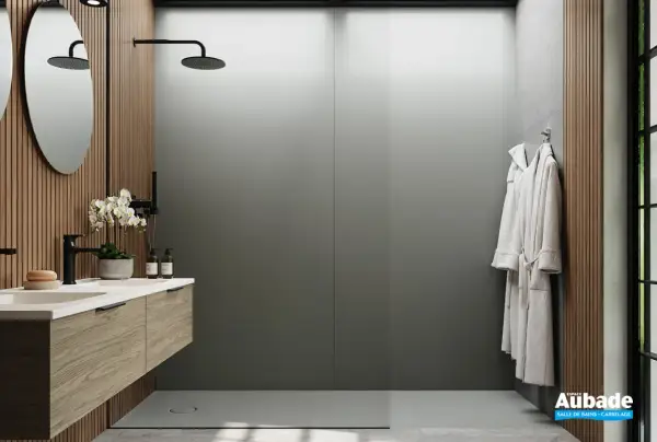 Salle de bain moderne avec lavabo en bois, douches et peignoirs. Le receveur de douche, discret, s'intègre parfaitement.