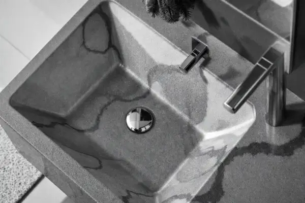 Lavabo évier moderne en béton gris veiné, avec robinetterie chromée. Un design épuré pour une salle de bain contemporaine.