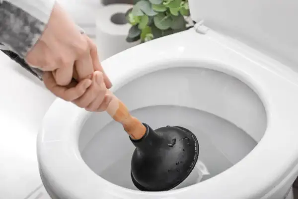 Main tenant utilise une ventouse pour comment deboucher wc.