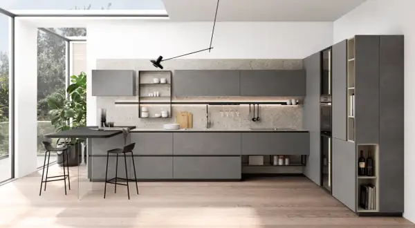 Plan cuisine en L moderne, gris, avec îlot, tabourets et grandes fenêtres.