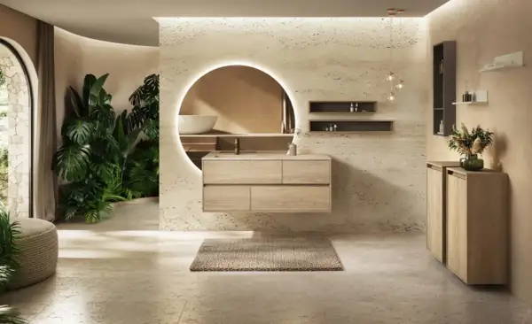 Une salle de bain moderne avec des plantes luxuriantes, un meuble-lavabo suspendu en bois clair et un grand miroir rond éclairé. Une véritable inspiration salle de bain.