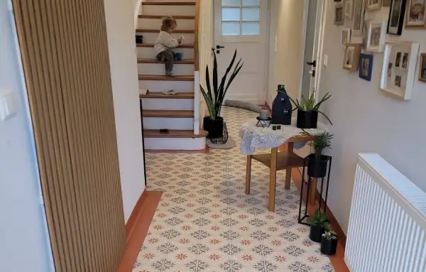 Un enfant sur les escaliers, un sol aux motifs floraux. Avis sur la peinture sur carrelage : un rendu chaleureux et moderne.